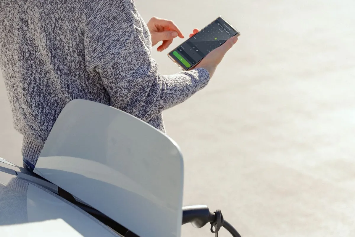 Person using the aConnect app to check charging status for their EV
